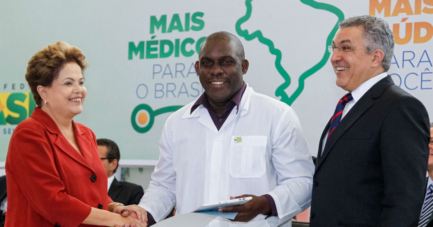 Presidenta Dilma Rousseff, médico cubano, Juan Delgado e o Ministro da Saúde Alexandre Padilha durante sanção da lei que institui o Programa Mais Médicos. Foto: Roberto Stuckert Filho / PR
